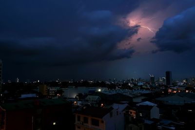 Illuminated cityscape against sky at night