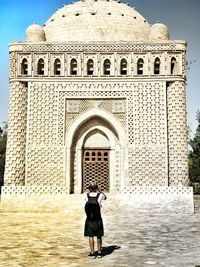 Rear view of woman standing at historical building