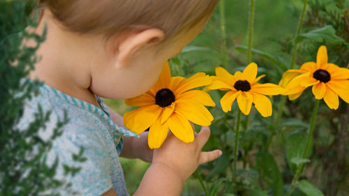 Close-up of hand holding yellow flower