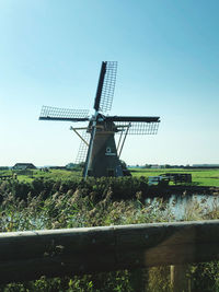 Traditional windmill on field against clear sky