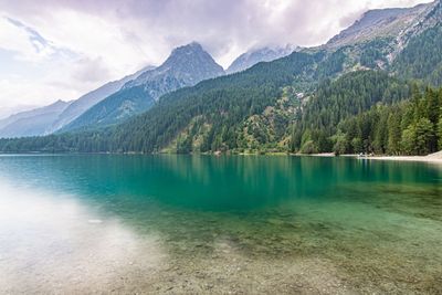 Scenic view of lake by mountains against sky