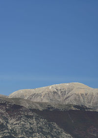 Scenic view of snowcapped mountains against clear blue sky