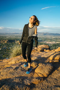 Young woman standing on mountain against sky