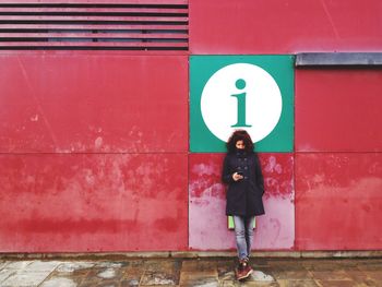 Full length of woman standing on wall