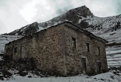 Snow covered mountain against cloudy sky