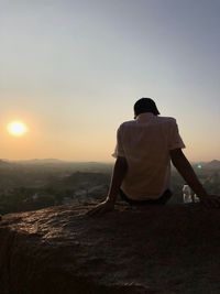 Rear view of man looking at sunset