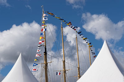 High section of sunshades against colorful flags on ship masts
