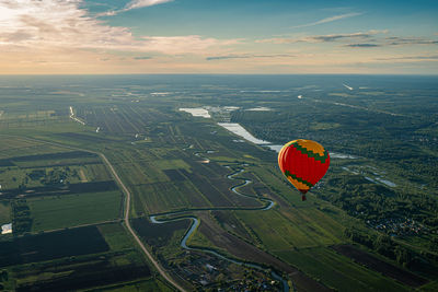 Hot air balloon flying over landscape against sky