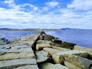 Scenic view of sea breakwater against sky