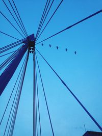 Low angle view of suspension bridge against clear blue sky