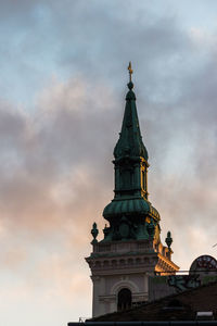Statue in city against cloudy sky