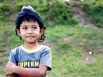 Cute smiling boy looking away while standing outdoors