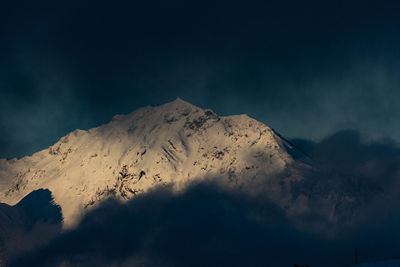 Low angle view of snowcapped mountain against sky