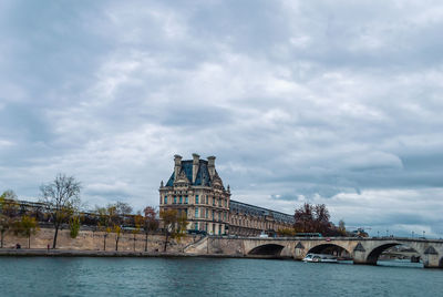 Arch bridge over river against buildings