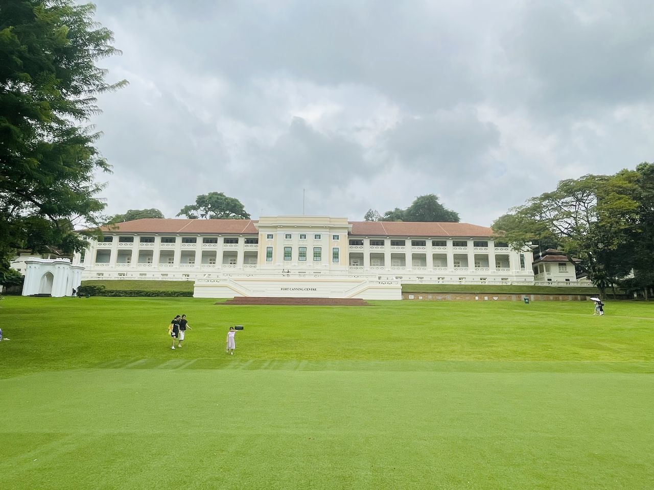 sport venue, sports, stadium, architecture, grass, lawn, baseball field, built structure, plant, cloud, sky, soccer-specific stadium, building exterior, nature, travel destinations, estate, green, tree, leisure activity, day, activity, group of people, cricket, outdoors, travel, city, baseball park, flag