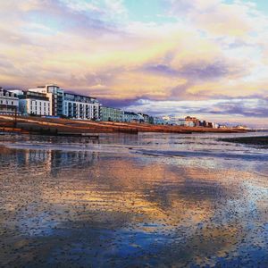 Reflection of cloudy sky on water at sunset