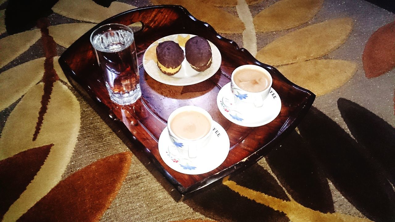 food and drink, table, indoors, still life, high angle view, drink, freshness, coffee cup, refreshment, coffee - drink, food, plate, sweet food, spoon, directly above, close-up, cup, wood - material, saucer, dessert