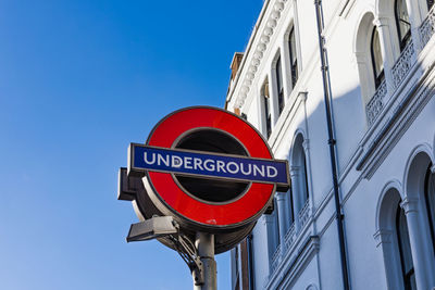 Subway entrance sign for london underground near historic white building