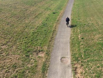 High angle view of man riding bicycle on footpath