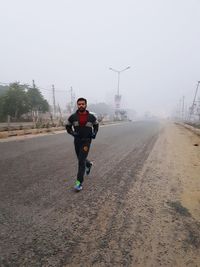 Full length of young woman running in winter