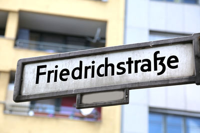 Low angle view of information sign against building in city
