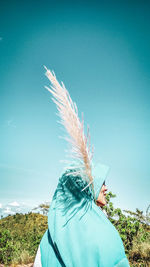 Rear view of woman on field against clear blue sky