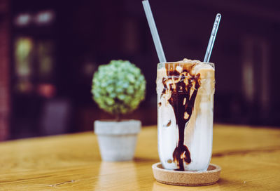 Iced coffee with plenty milk on the wooden table.