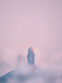 Lighthouse by sea against sky