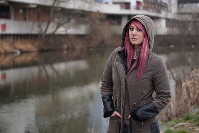 Portrait of confident woman standing against building