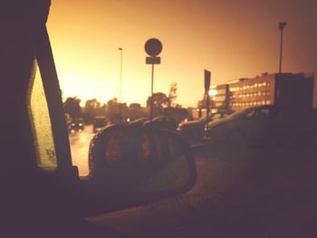 Vehicles on road at sunset