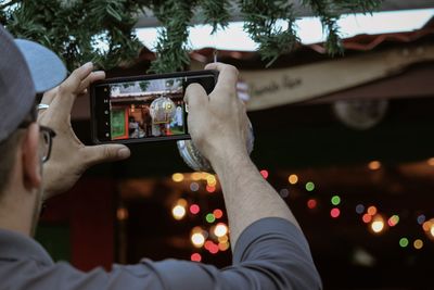 Midsection of man photographing using mobile phone