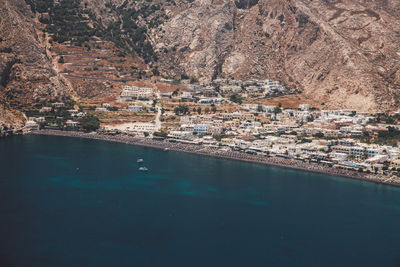 Scenic view of river by buildings on sunny day