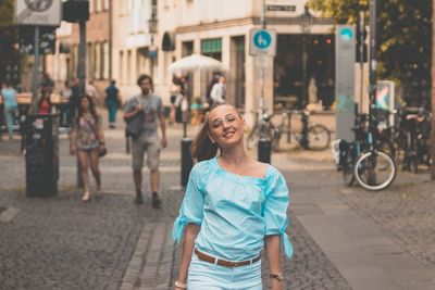 Portrait of young woman on city street