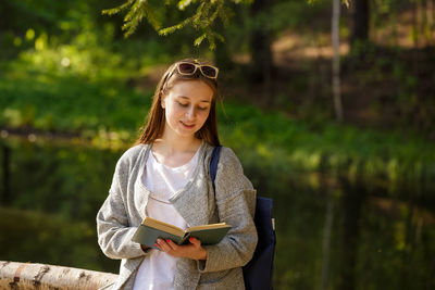 Cute girl in the park with a book in hand