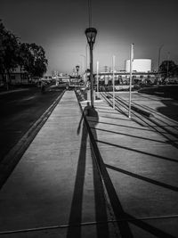 Street lights on road against sky in city