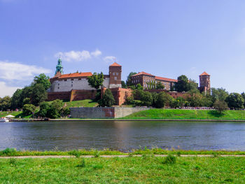 Buildings by river against clear sky