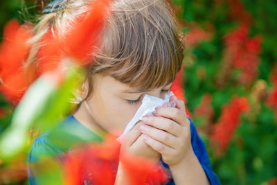 Close-up of girl blowing bubbles in park