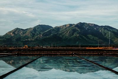 Swimming pool by mountains against sky