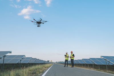 Low angle view of man photographing against sky