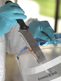 Forensic scientist bagging a knife taken from a violent crime scene