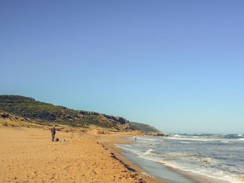 Scenic view of beach against clear blue sky