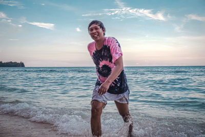 Woman standing at beach against sky