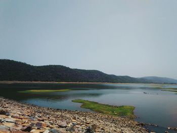 Scenic view of lake and mountains against clear sky