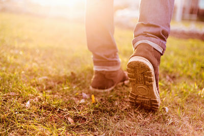 Low section of man standing on field