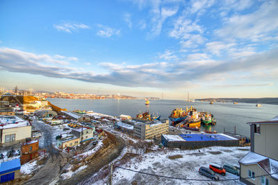 High angle view of buildings by sea against sky during winter