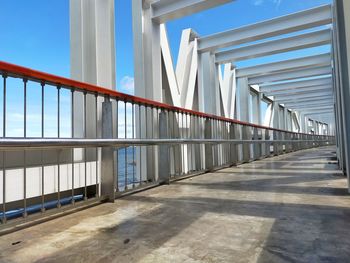 Empty footpath by building against clear sky