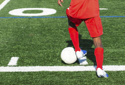 Low section of person playing soccer on field