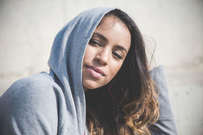 Close-up portrait of beautiful young woman wearing hoodie