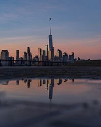 Reflection of buildings in city at sunset