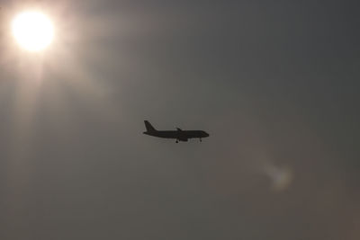 Low angle view of silhouette airplane against sky during sunset